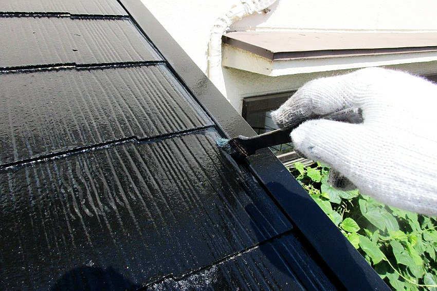 細かい部分をハケで塗装中の屋根