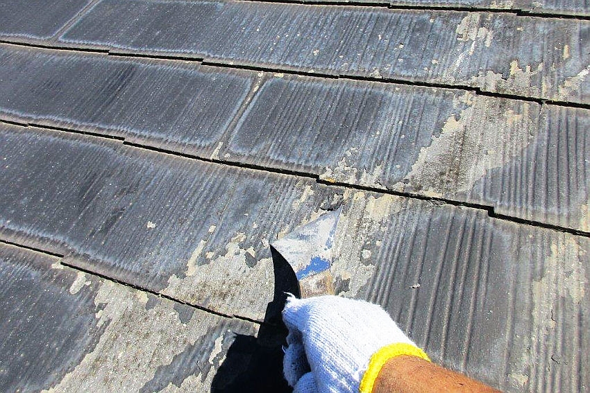 古い塗膜をケレン掛け作業中の屋根